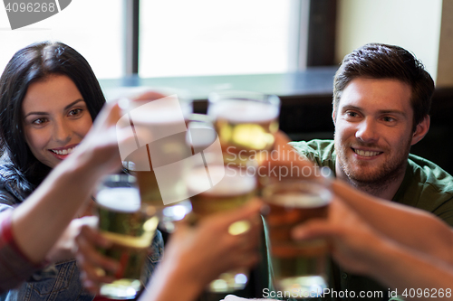 Image of happy friends drinking beer at bar or pub