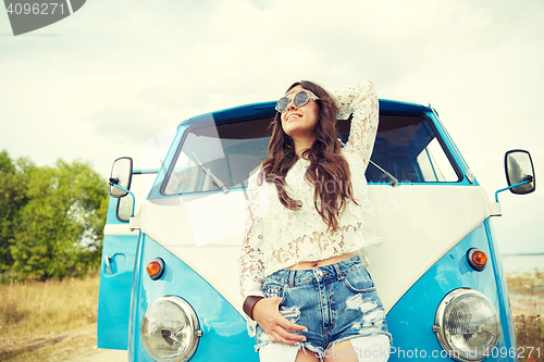 Image of smiling young hippie woman in minivan car