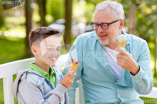 Image of old man and boy eating ice cream at summer park