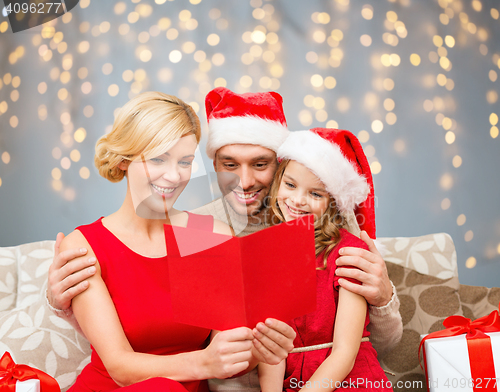 Image of happy family reading christmas postcard