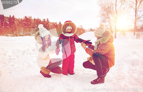 Image of happy family with child in winter clothes outdoors
