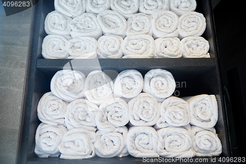 Image of rolled white bath towels at hotel spa