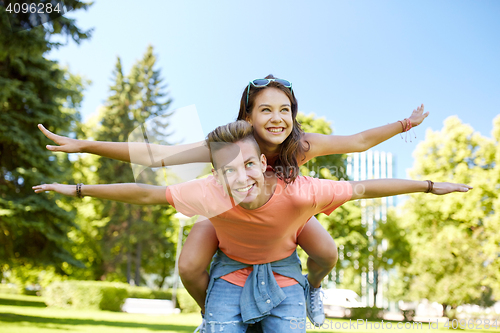 Image of happy teenage couple having fun at summer park