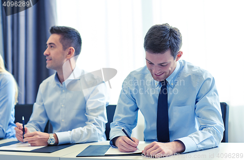 Image of group of smiling businesspeople meeting in office