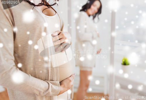 Image of close up of pregnant woman looking to mirror