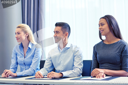 Image of group of smiling businesspeople meeting in office