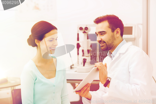 Image of optician with tablet pc and patient at eye clinic