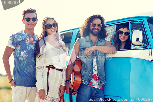 Image of smiling young hippie friends over minivan car