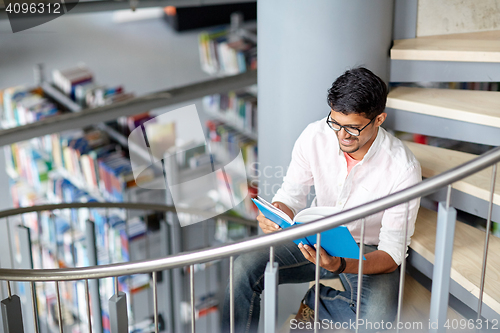 Image of hindu student boy or man reading book at library