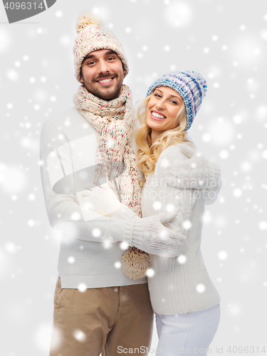 Image of smiling couple in winter clothes hugging