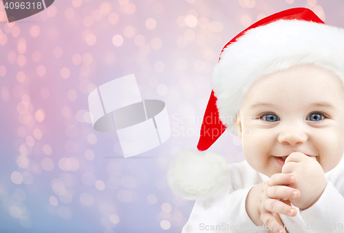 Image of happy baby in santa hat over holidays lights