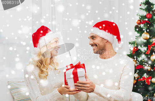 Image of happy couple at home with christmas gift box
