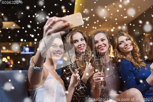 Image of women with champagne taking selfie at night club