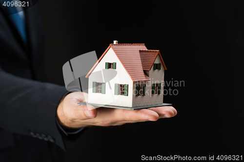 Image of close up of businessman hand holding house model