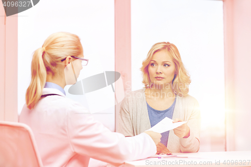 Image of doctor giving prescription to woman at hospital