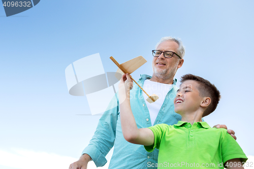 Image of senior man and boy with toy airplane over sky