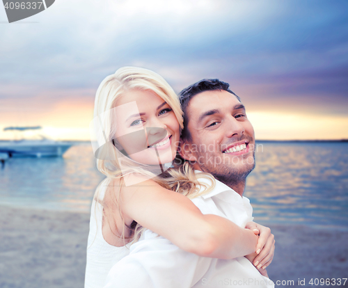 Image of couple having fun and hugging on beach