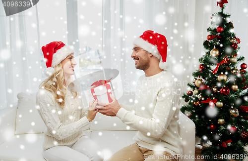 Image of happy couple at home with christmas gift box