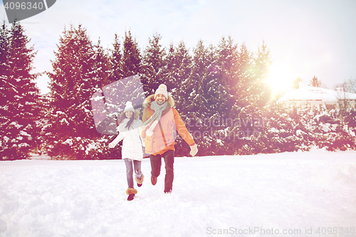 Image of happy couple running in winter snow