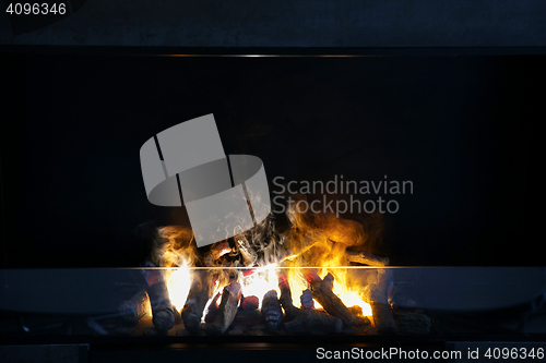 Image of flame of firewood burning in modern fireplace