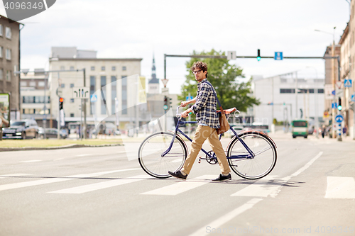 Image of young man with fixed gear bicycle on crosswalk