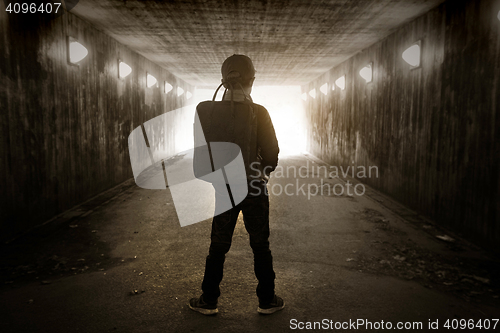 Image of School child walking in a dark subway 