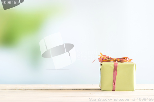 Image of Present on a bright table in green paper