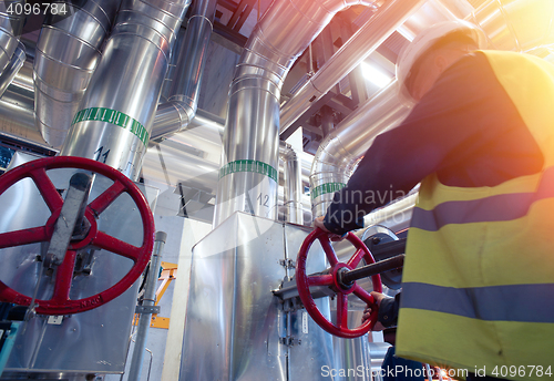 Image of factory worker turning valve