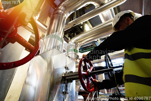 Image of factory worker turning valve