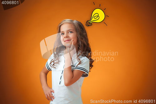 Image of The cute cheerful little girl on orange background