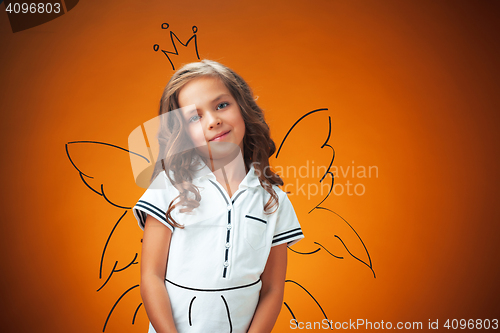 Image of The cute cheerful little girl on orange background