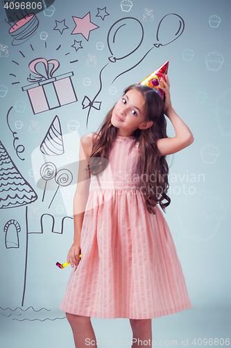 Image of The cute cheerful little girl with festive cap on gray background
