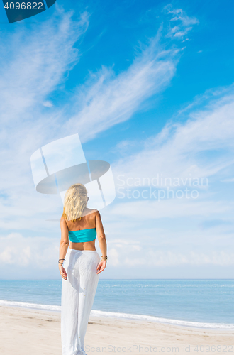 Image of portrait of young pretty woman looking to the ocean 