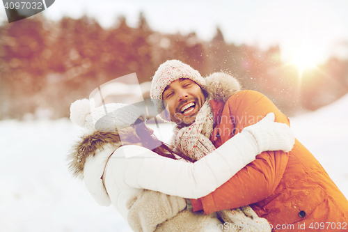 Image of happy couple hugging and laughing in winter