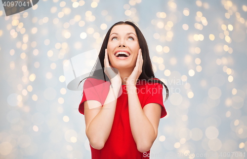 Image of amazed laughing young woman in red dress