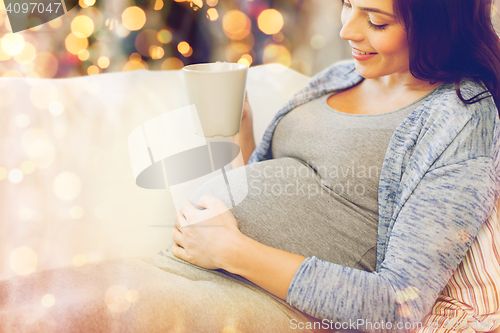 Image of close up of pregnant woman drinking tea at home