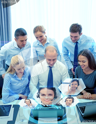 Image of smiling business people with laptop in office