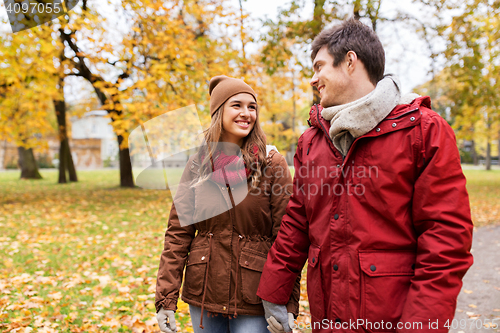 Image of happy young couple walking in autumn park