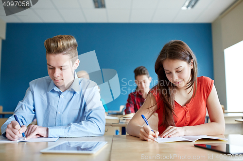 Image of group of students with books writing school test