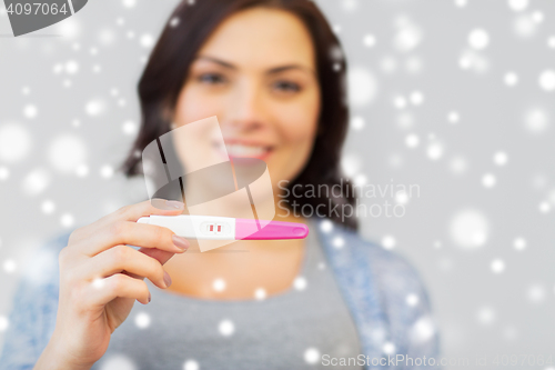 Image of happy woman with home pregnancy test