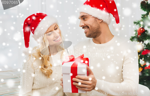 Image of happy couple at home with christmas gift box