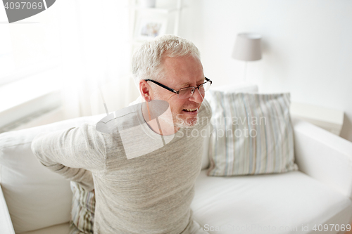 Image of unhappy senior man suffering from backache at home