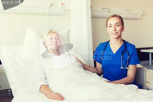 Image of doctor or nurse visiting senior woman at hospital