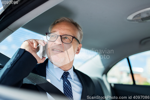 Image of senior businessman calling on smartphone in car