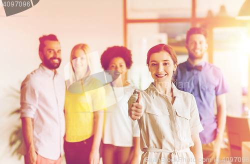 Image of woman showing thumbs up over creative office team