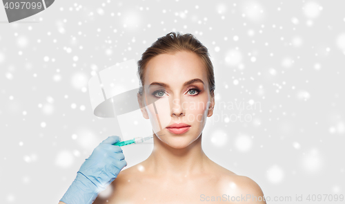 Image of woman face and hand with syringe making injection