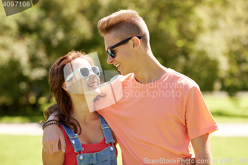 Image of happy teenage couple looking at each other in park