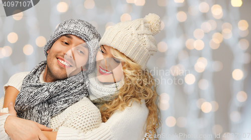 Image of happy family couple in winter clothes hugging