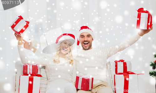 Image of happy couple at home with christmas gift boxes