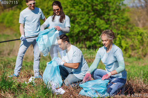 Image of volunteers with garbage bags cleaning park area